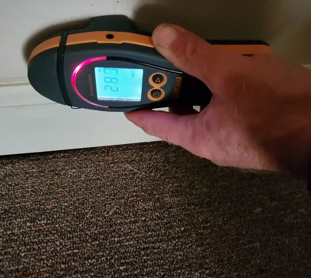 Moisture detection at baseboard during Storm Damage Restoration in Tice